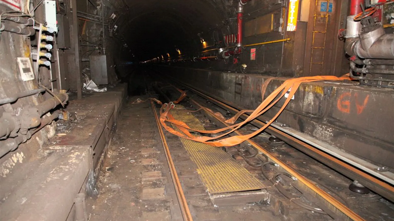 Mine tunnel with high-pressure hose lines along the track