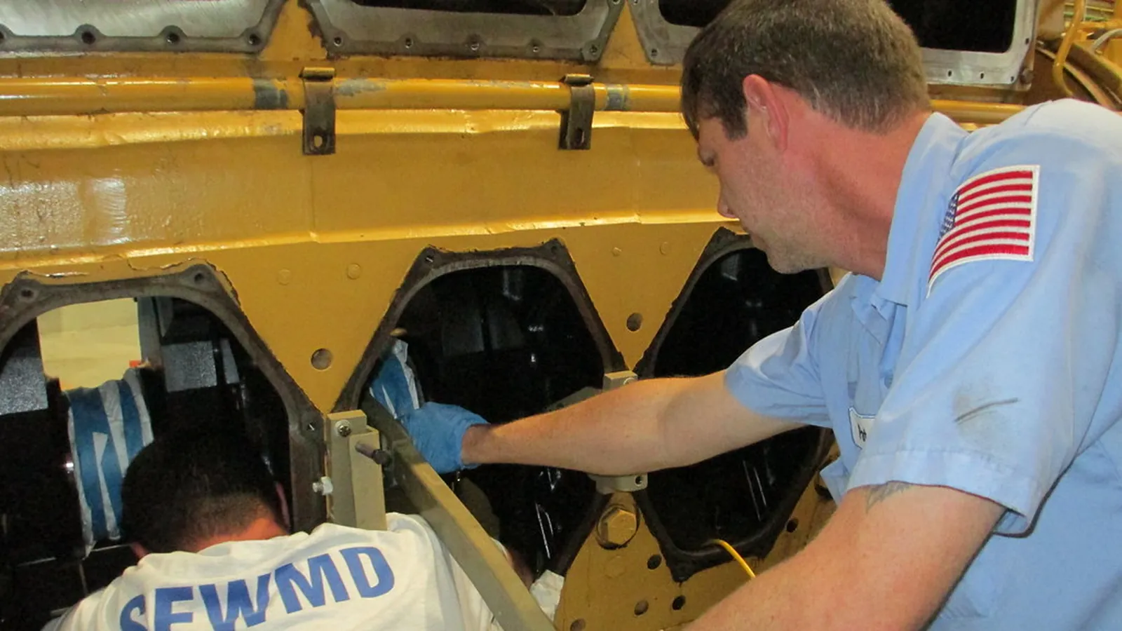 Maintenance engineer working on a yellow pump casing