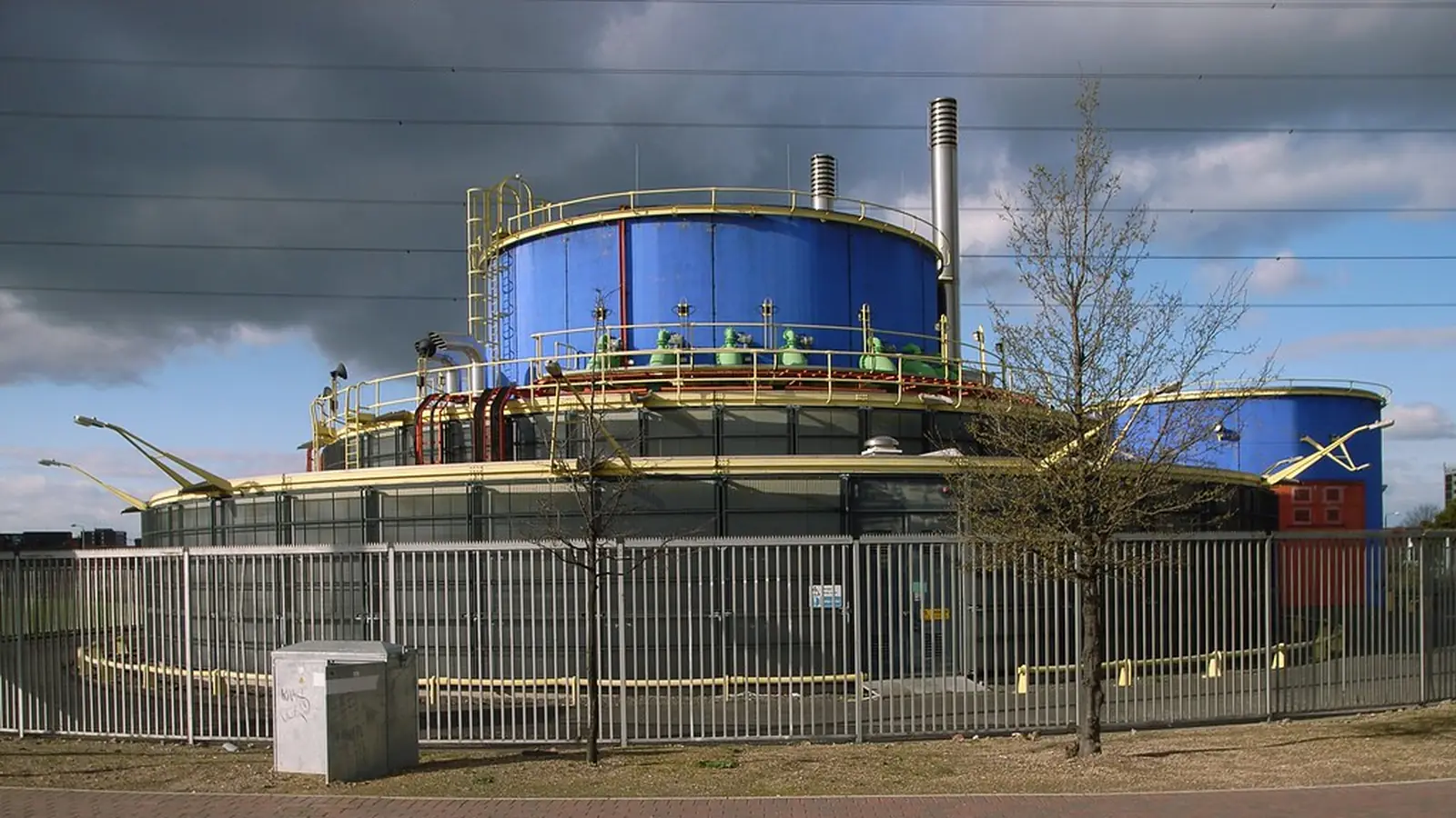 Cylindrical storage tanks behind a safety fence at a water plant