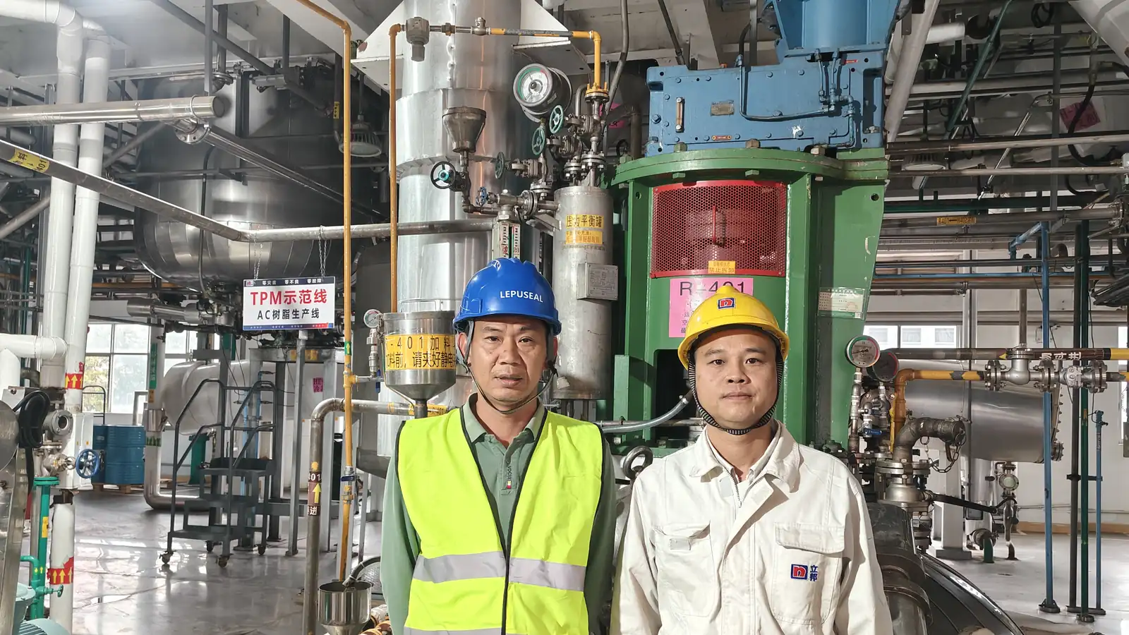 Two workers installing pipework in a mechanical seal plant
